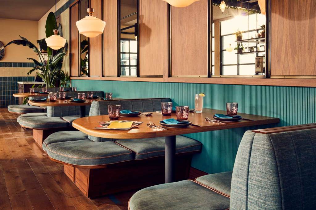 Three comfortable seating booths along a wall, each of which can seat up to four people