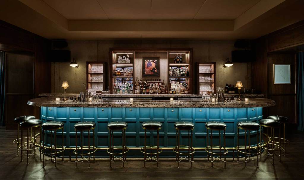 Eleven bar stools sit around the bar which has subtle lighting and a large selection of alcohol
