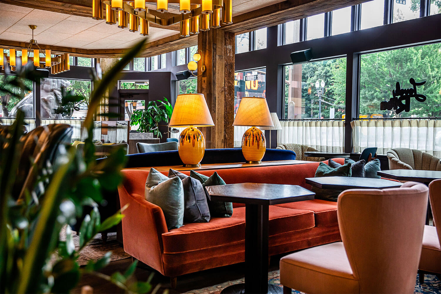 Burnt orange coloured sofa and other seating in the hotel lobby, which has large windows on both visible walls