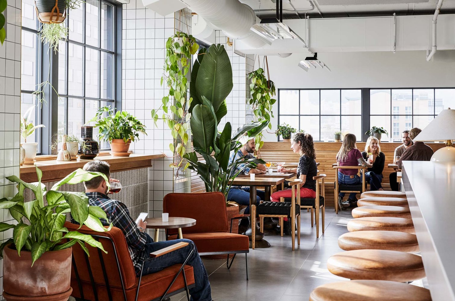 Guests sharing cocktails at various tables in the restaurant
