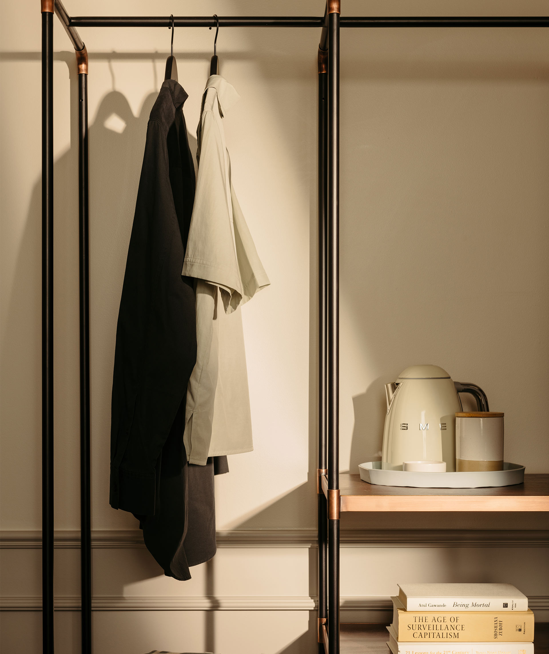 Clothes hanging up beside a kettle in the guest room