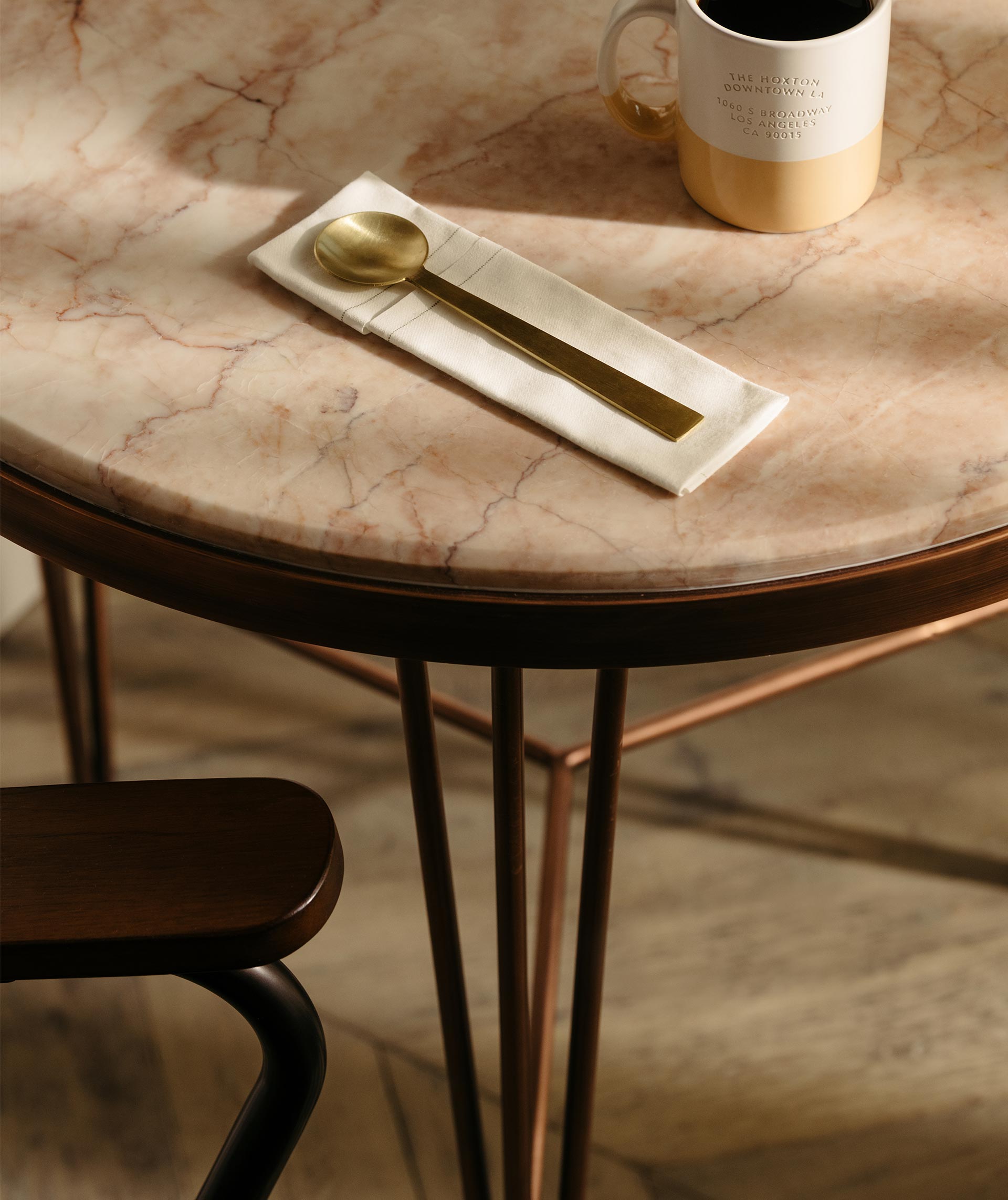 A gold spoon and mug sitting on a table