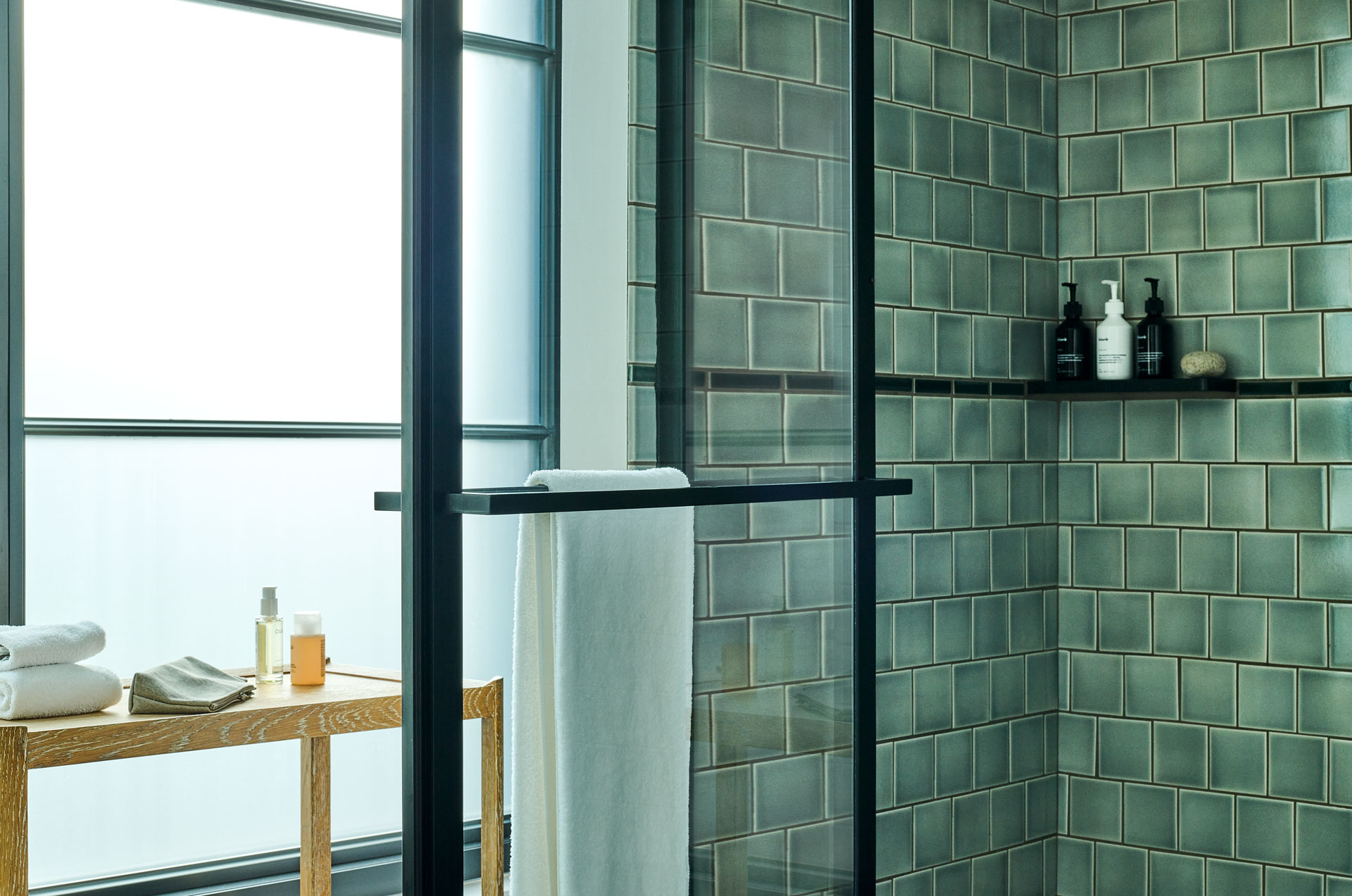 Shower with Blank toiletries and soft white towel beside