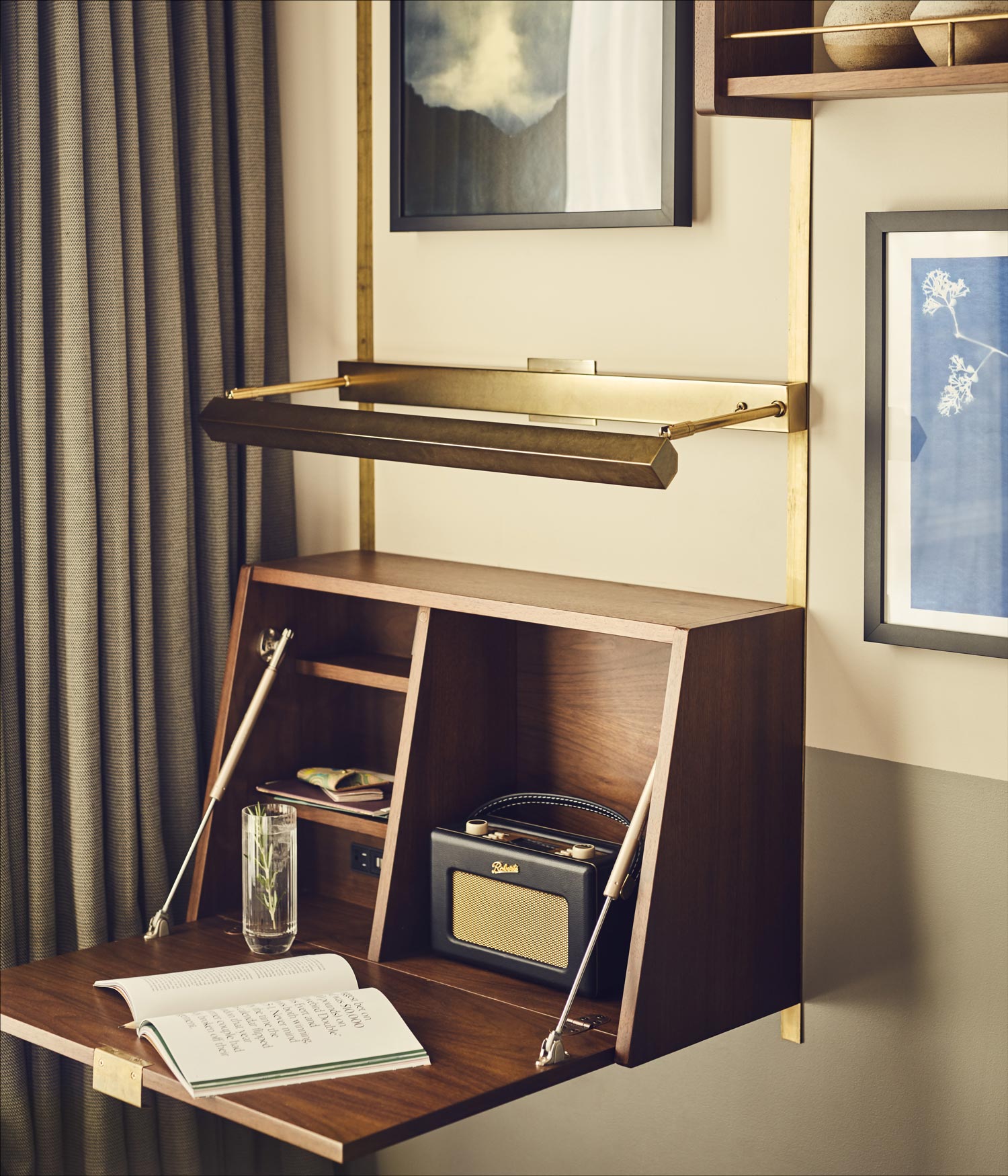 A small bureau desk folds down from the wall, containing a Roberts radio