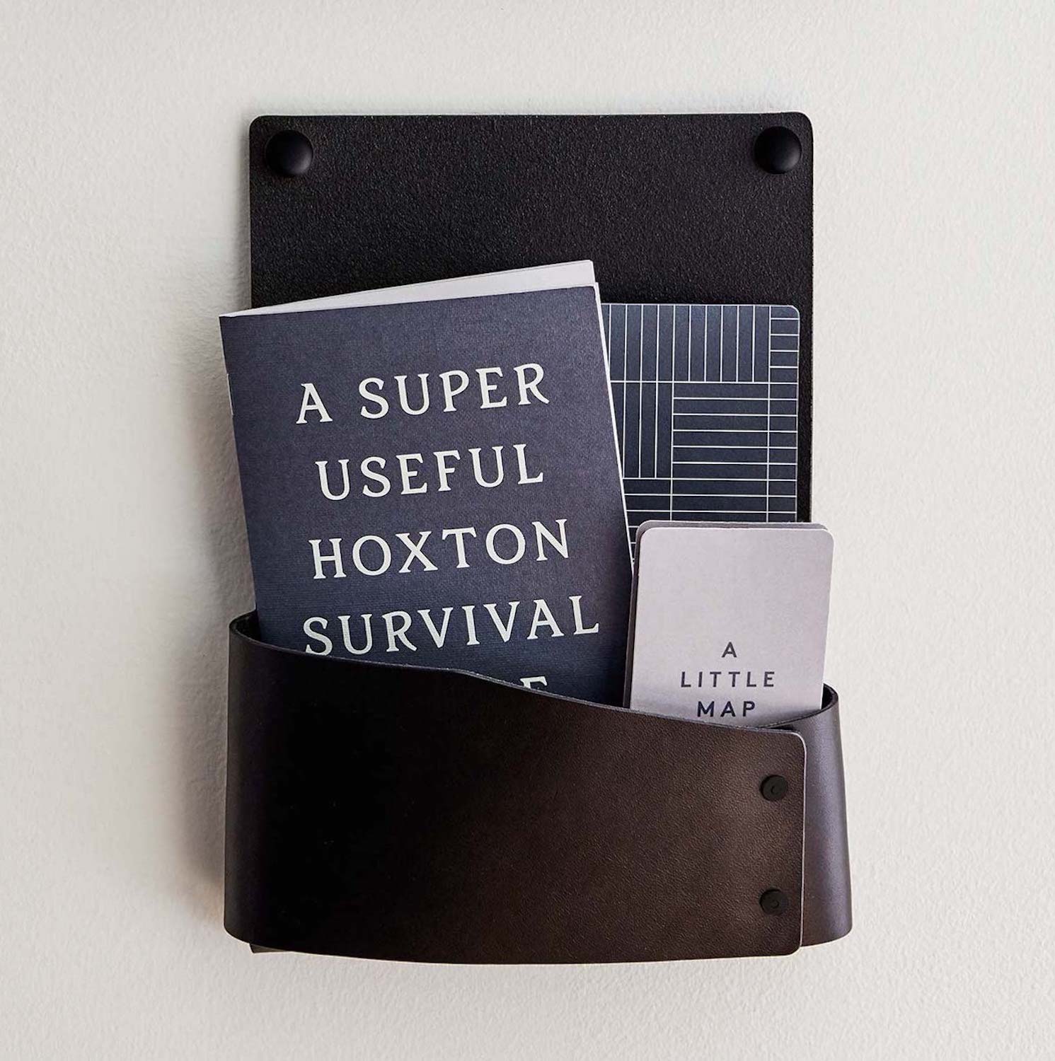 "A Super Useful Hoxton Survival Guide" and map sit in a holder on the wall