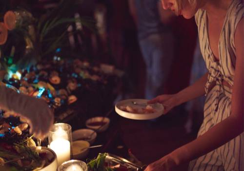 Woman getting food from a table at a party