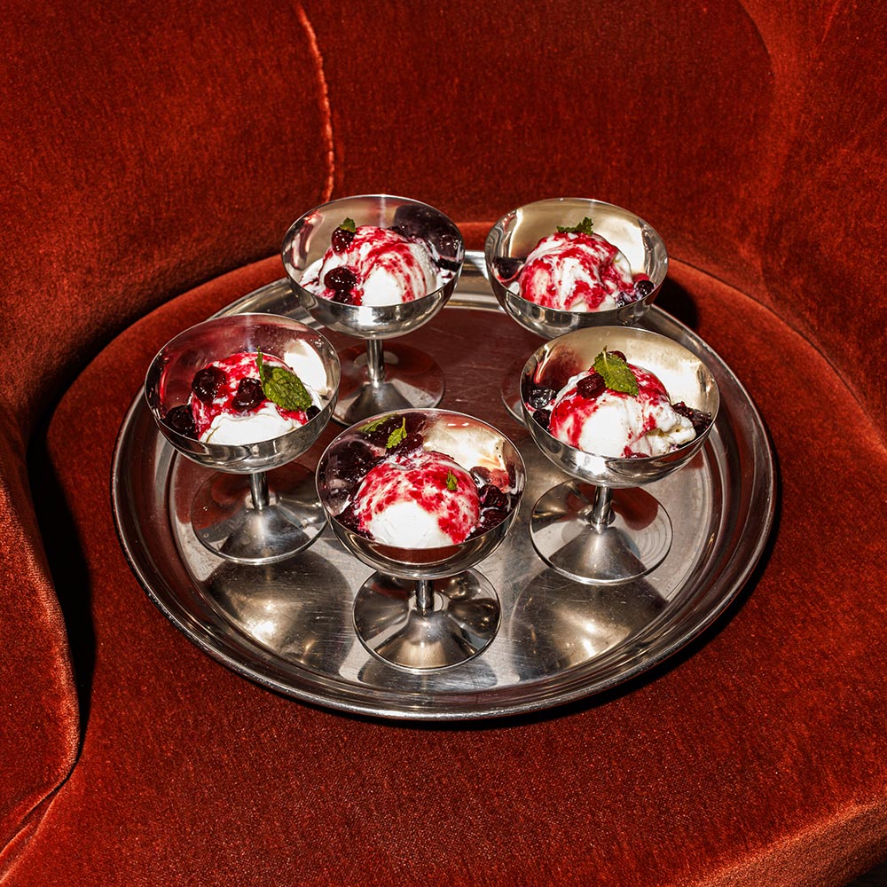 Tray of fruity ocktails lays on a plush velvet chair