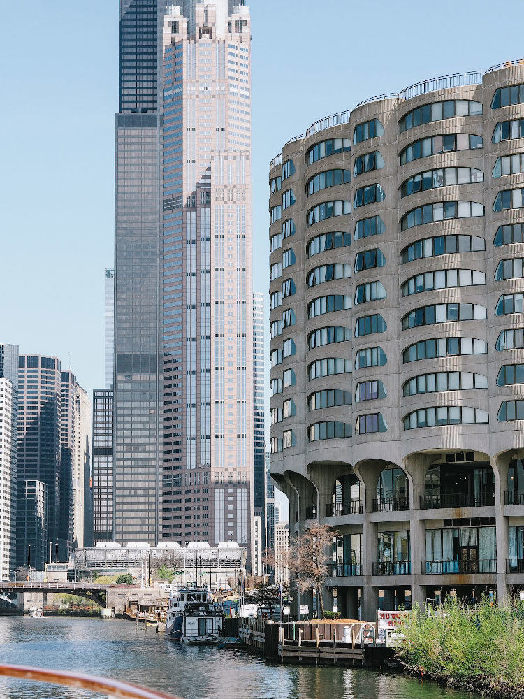 Tall buildings and blue skies sit behind a river