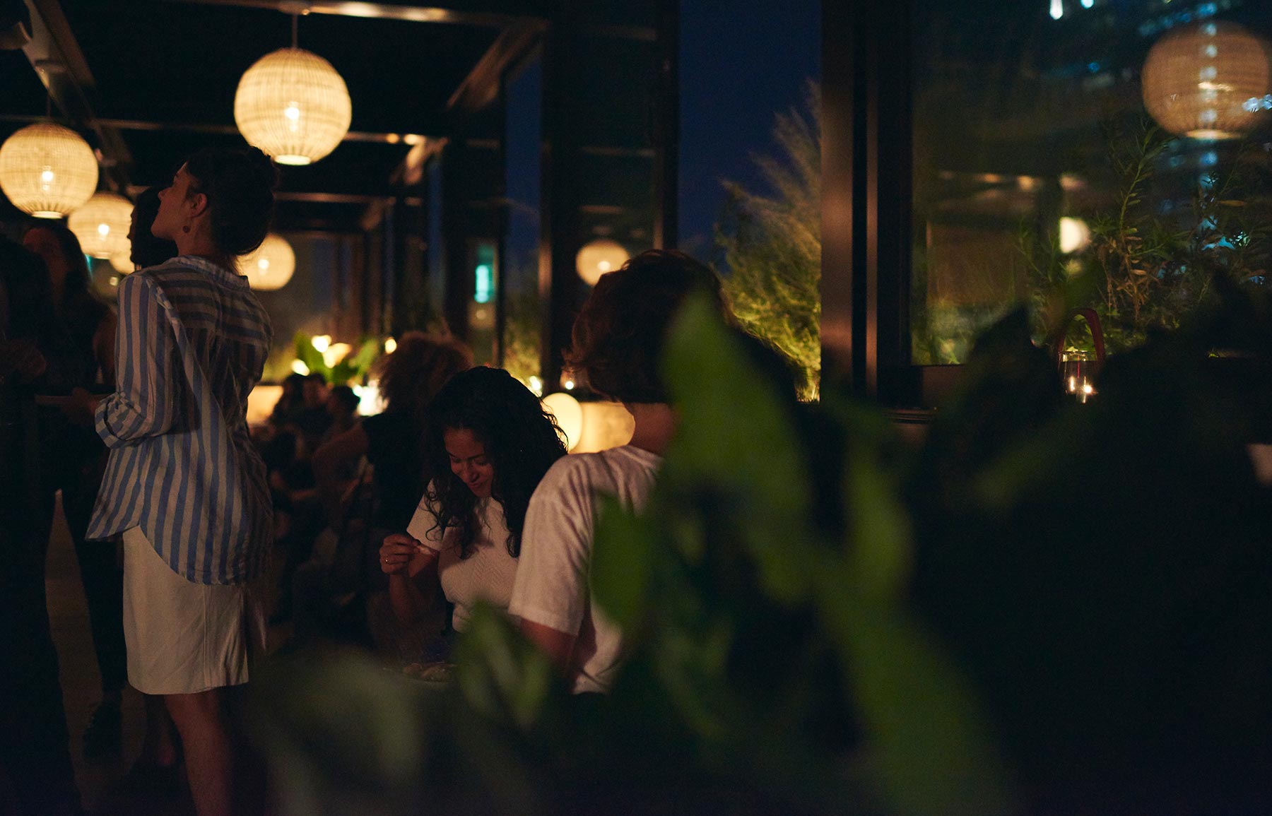 Dimly lit bar at night, full of guests enjoying a party