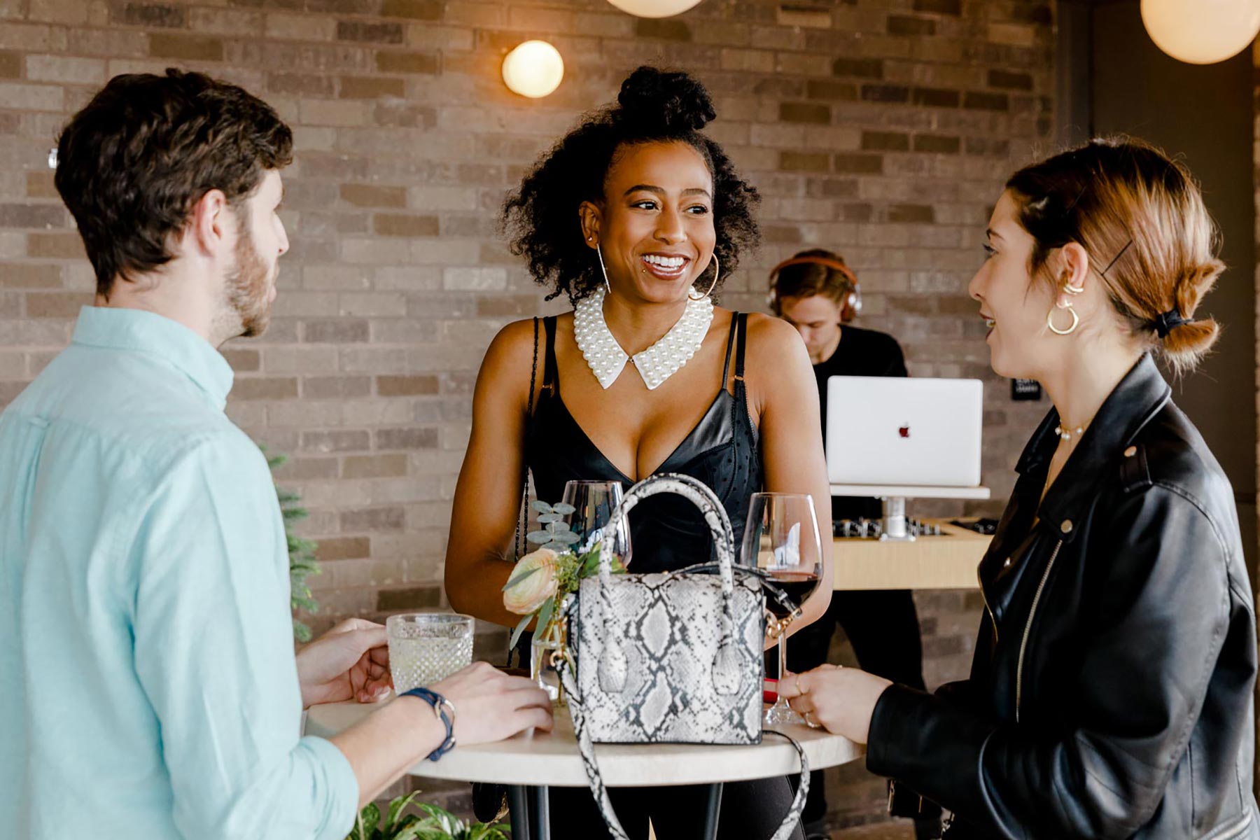 Guests at a party in Williamsburg with a DJ in the background