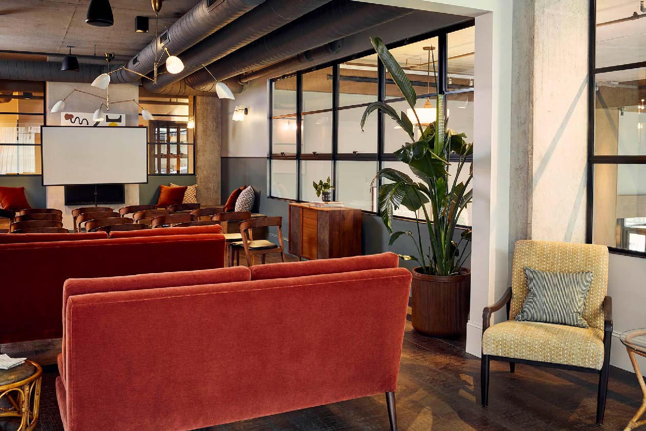 A room set up for a movie, with individual chairs in rows at the front and then sofas at the back