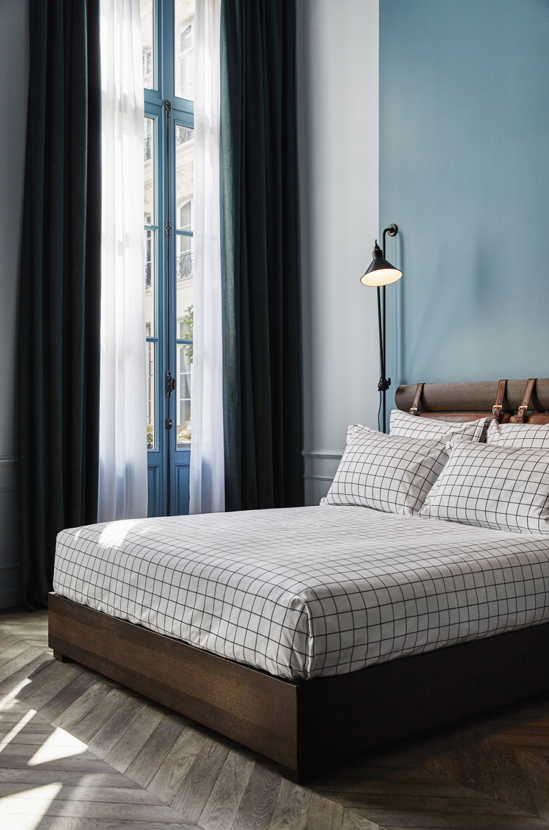 Bedroom with blue walls and floor to ceiling windows