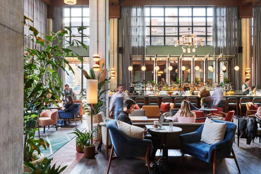 Guests on laptops or meeting friends for a drink in the hotel lobby