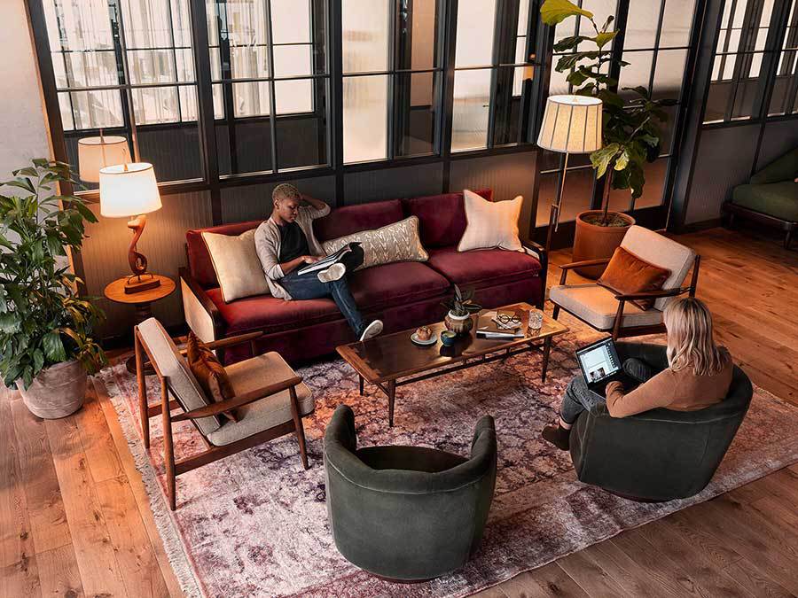 People on laptops sitting on comfortable seating in an open coworking space