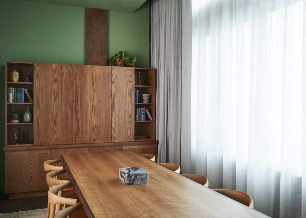 A modest-sized meeting room, with a long table with ten chairs.