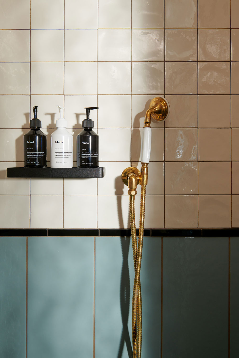 Gold shower head beside bathroom products on a shelf