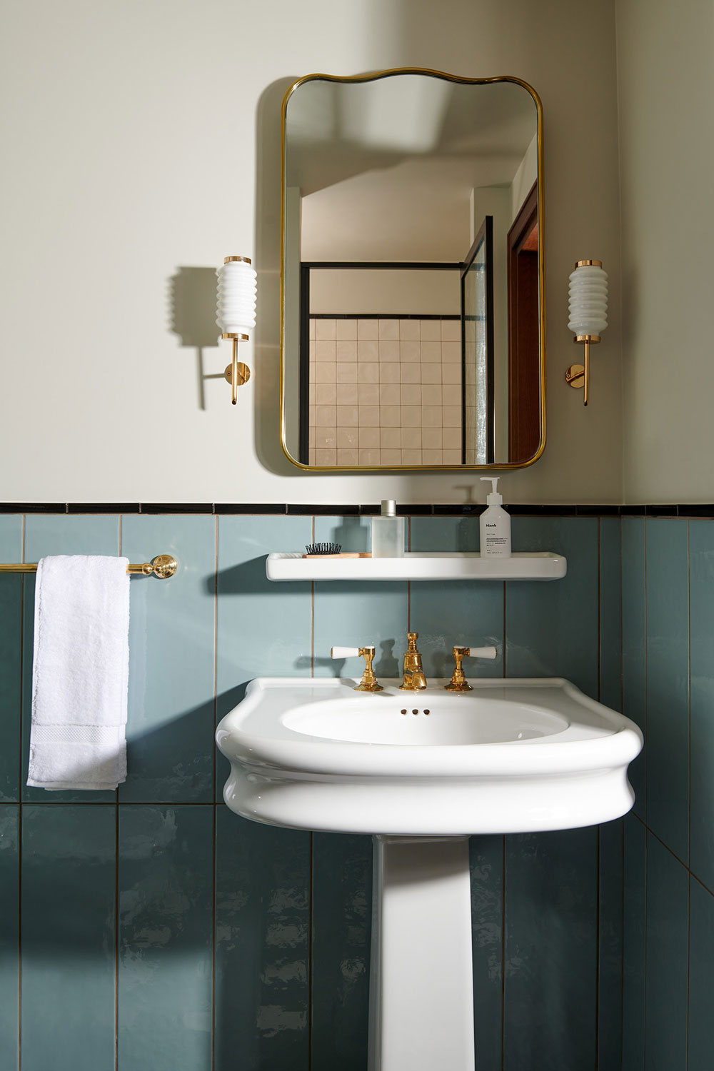 Hotel ensuite bathroom with mirror, sink and towel rail