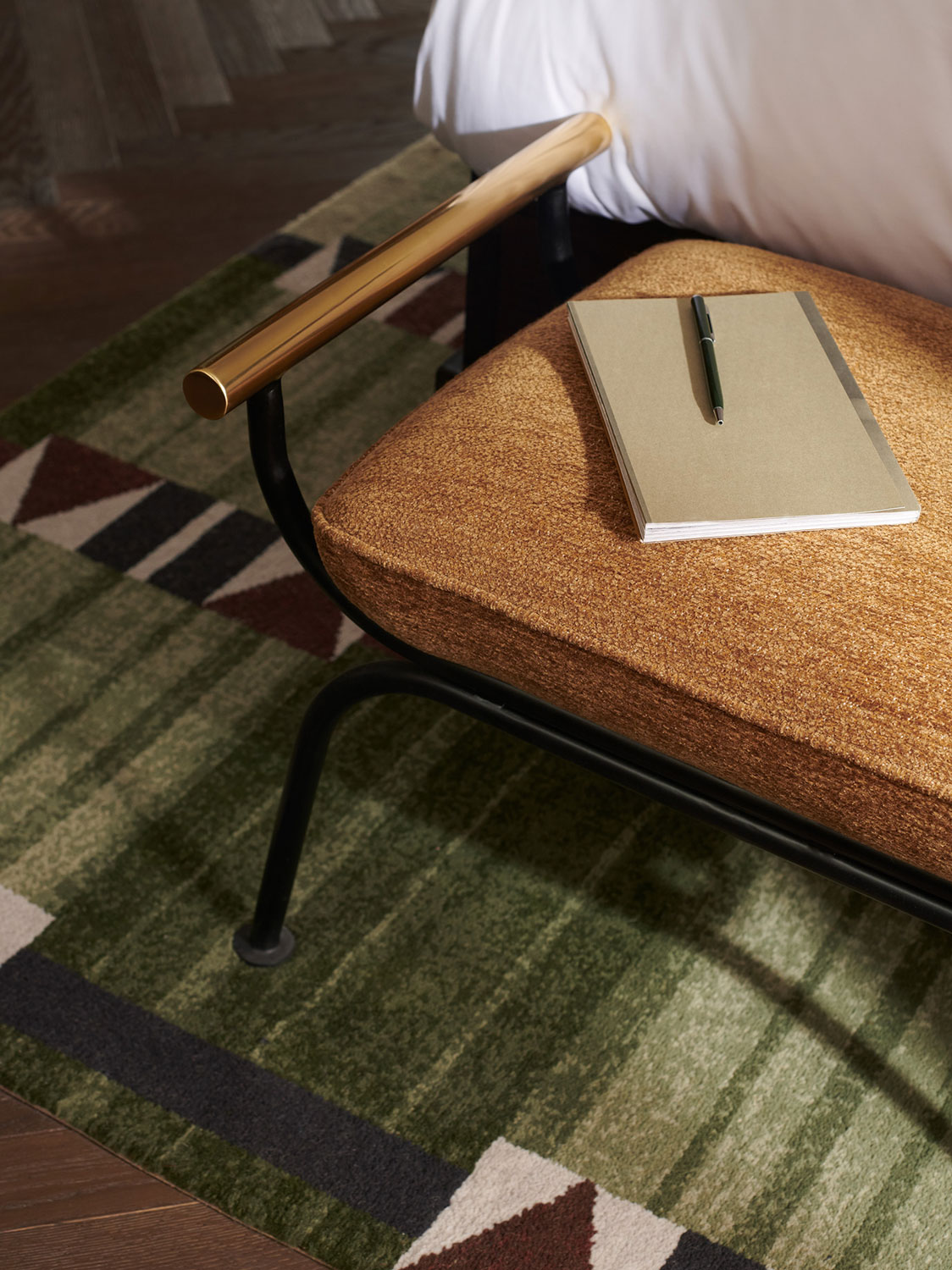 A notebook sits on a seat at the bottom of the bed