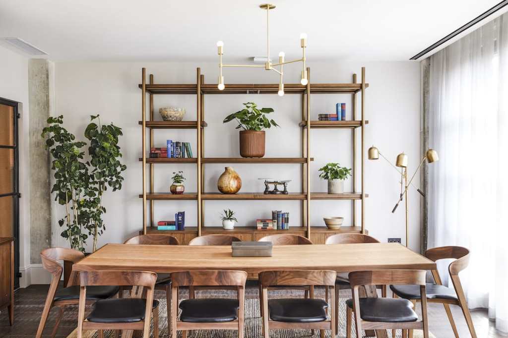 The Green room has decorative shelving, plants, and a long table for 10 guests