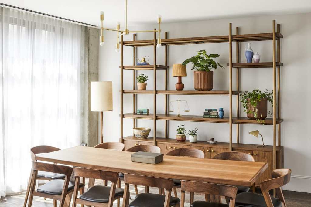 The meeting room is very bright with lots of natural light, and it has a long wooden table with 10 chairs.