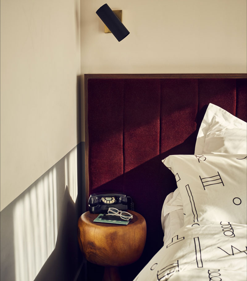 Telephone, reading glasses and notebooks sat on a side table beside the bed