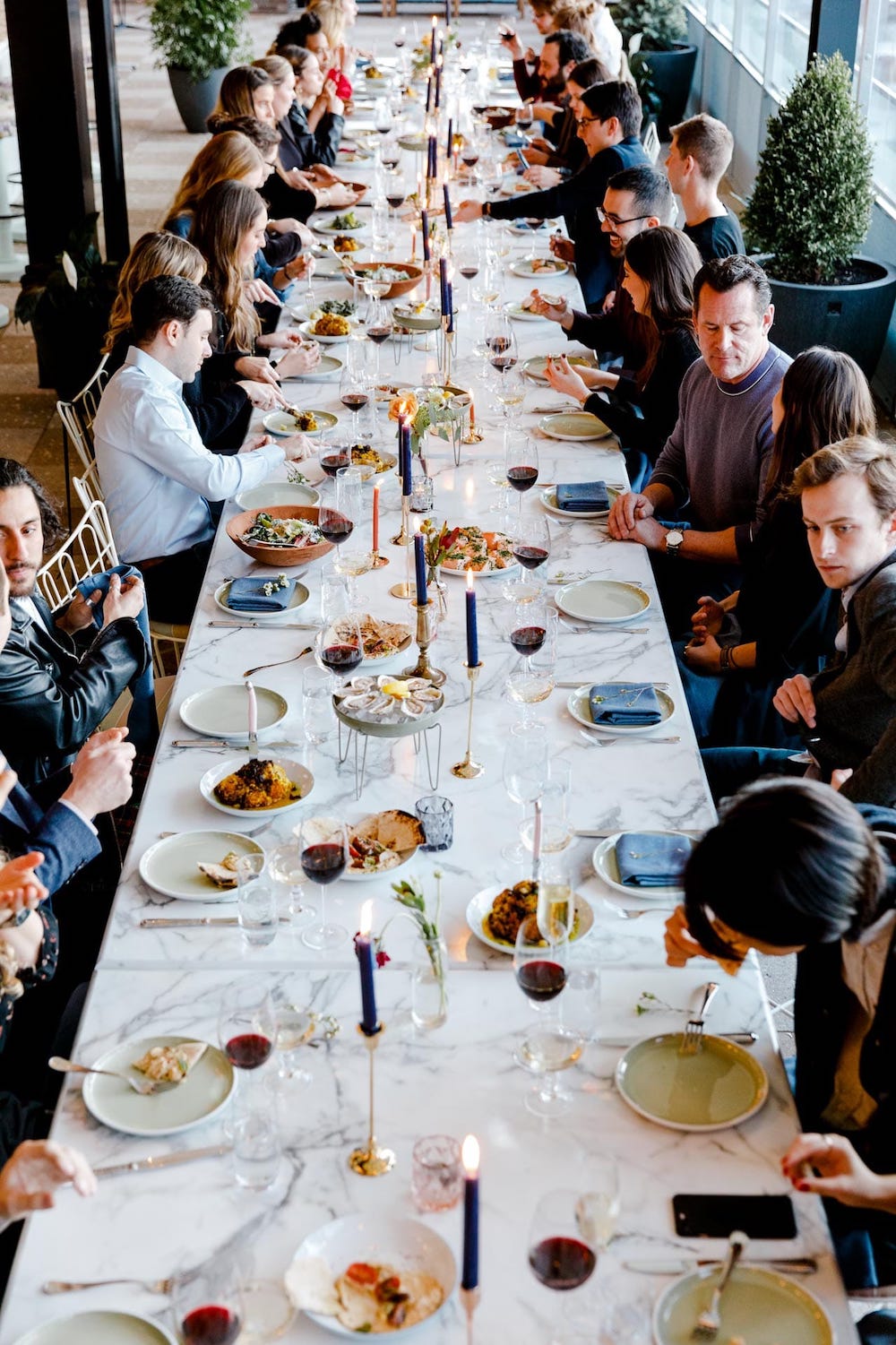 A very long table full of people talking and eating food