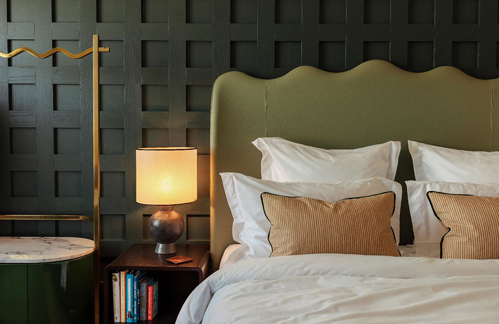 A lamp and books beside the bed
