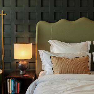 A lamp and books beside the bed