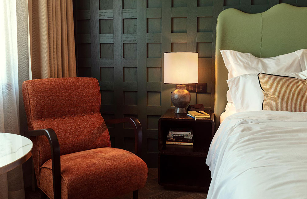 Comfortable orange lounge chair beside bed