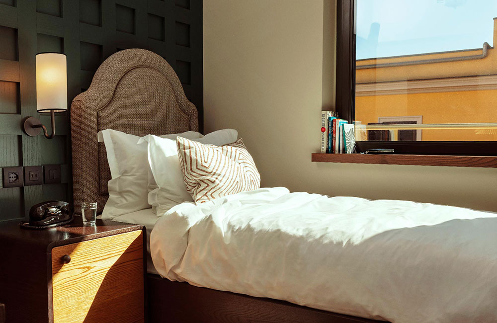 Single bed with sunlight streaming through the window