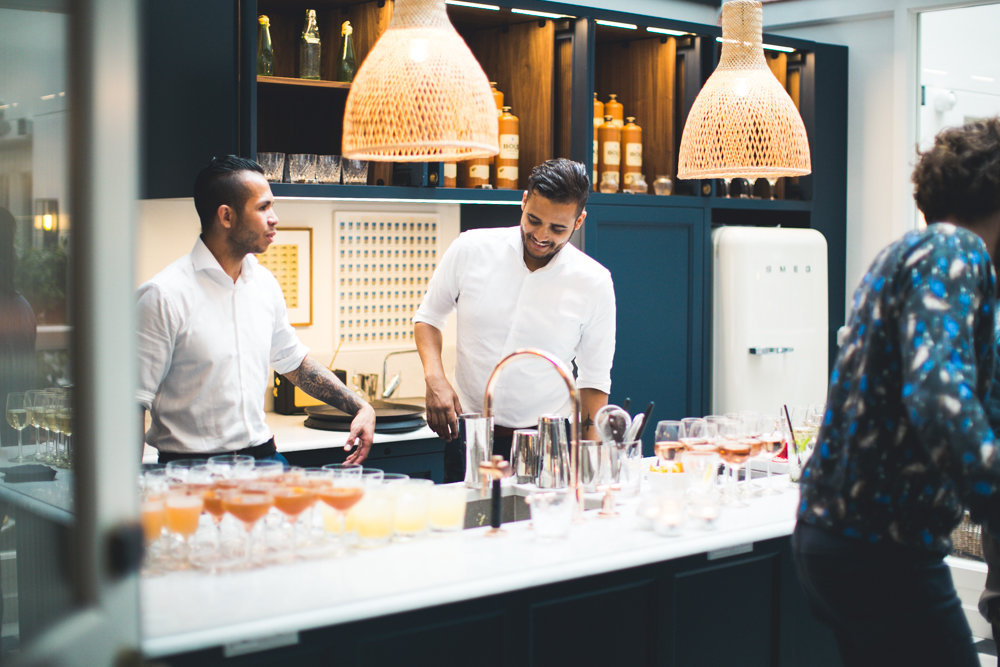 Staff in a white uniform, working behind the bar at an event