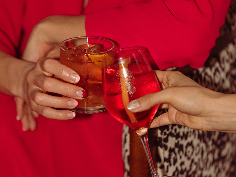 Un cocktail e un bicchiere di vino tintinnano nelle mani di due donne