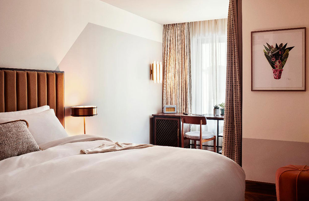 A desk sits in front of the window, with the large double bed in the foreground