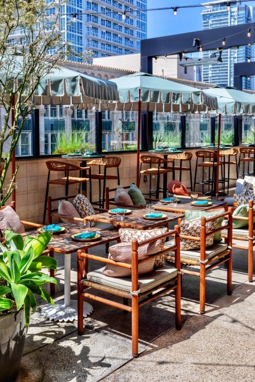Outdoor seating at Cabra rooftop with a view of the city.