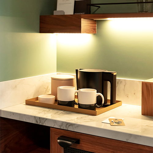 A tray with two mugs, kettle and container for tea bags