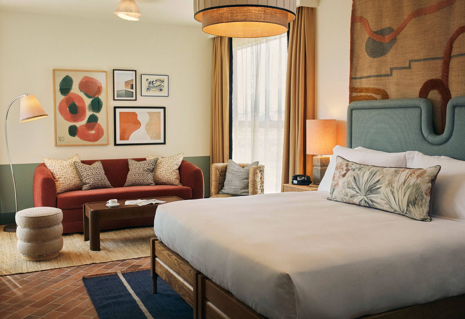 Hotel room with a large double bed and a lounge area with sofa and two chairs