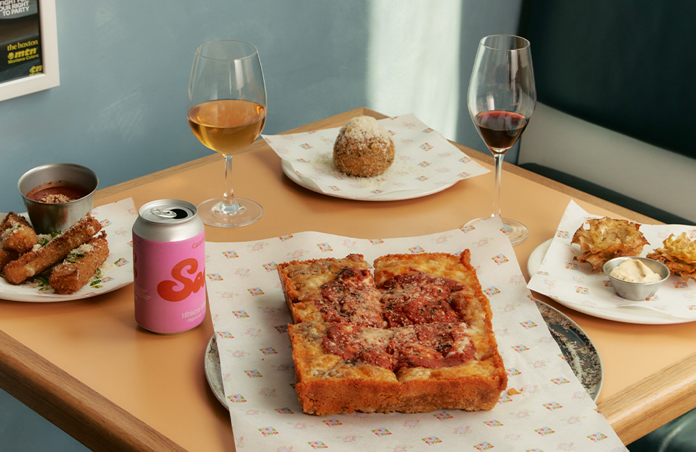 Booth for two with a table with various of dishes and drinks.