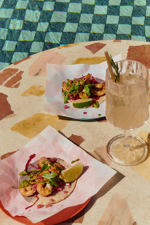 Tacos and refreshing drinks on a table beside the pool.