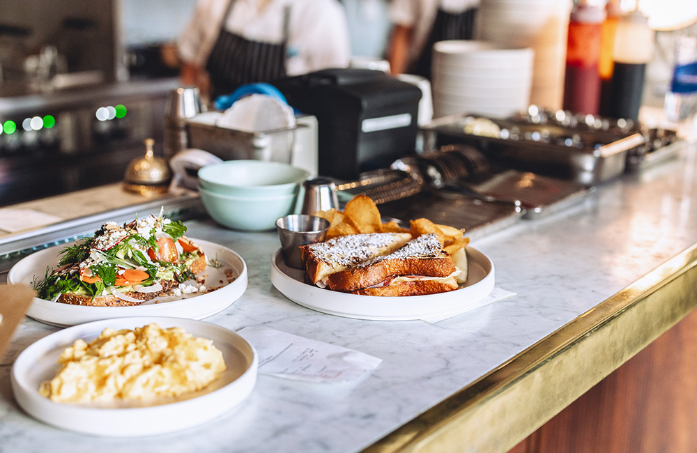 French toast, scrambled eggs and avocado toast served up on a marble tabletop