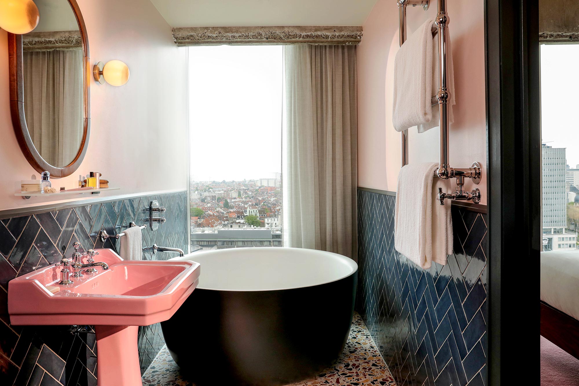Standalone tub affords the bather a view across Brussels through the window
