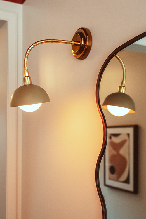 Stylish art deco wall light beside funky framed mirror.