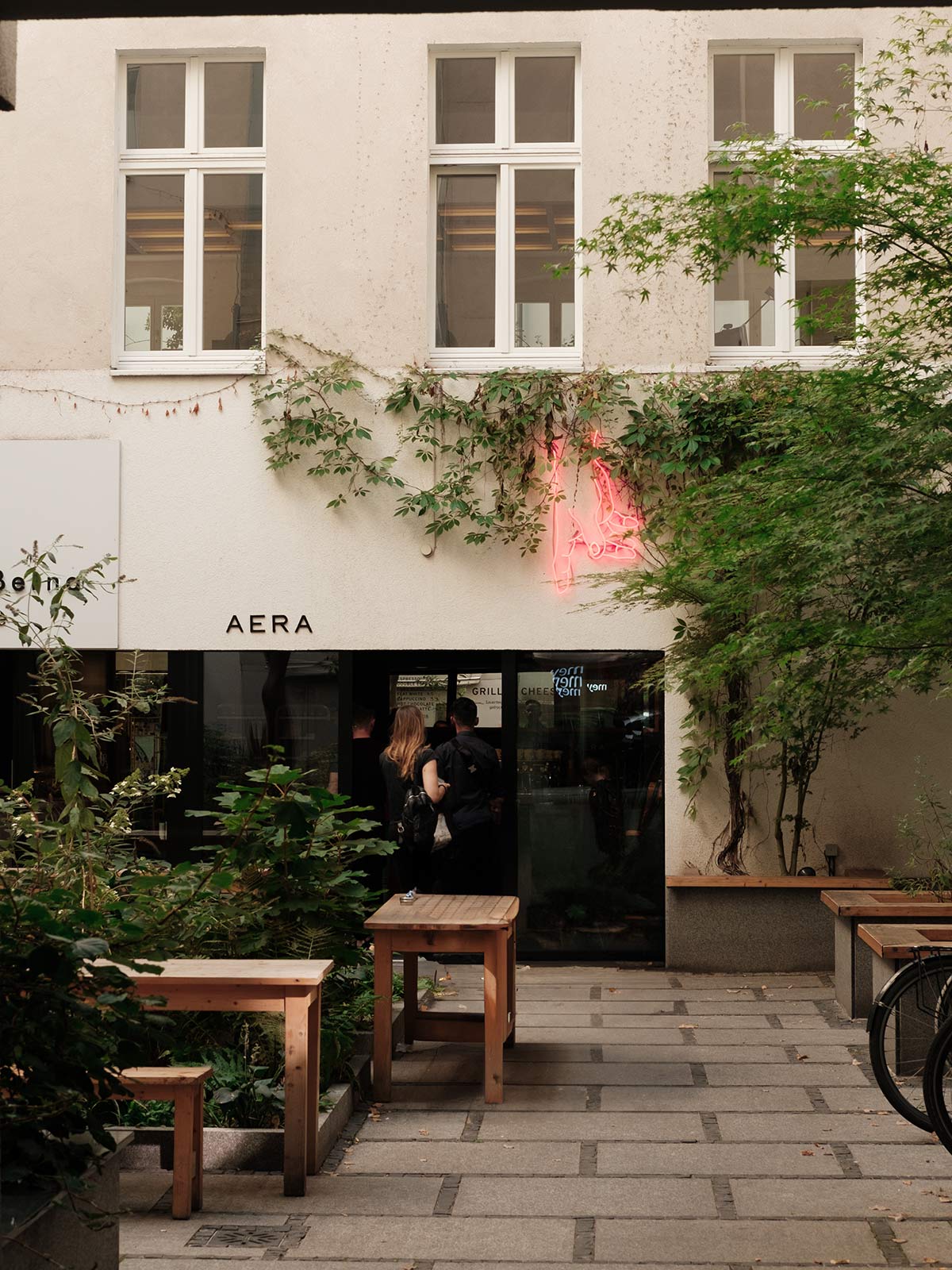 Exterior of the bakery with benches and flora