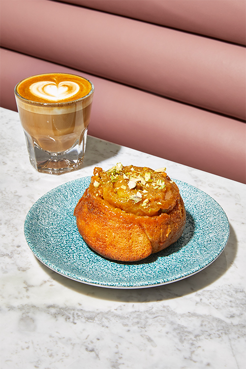 A rich pastry and coffee on a marble table surface.