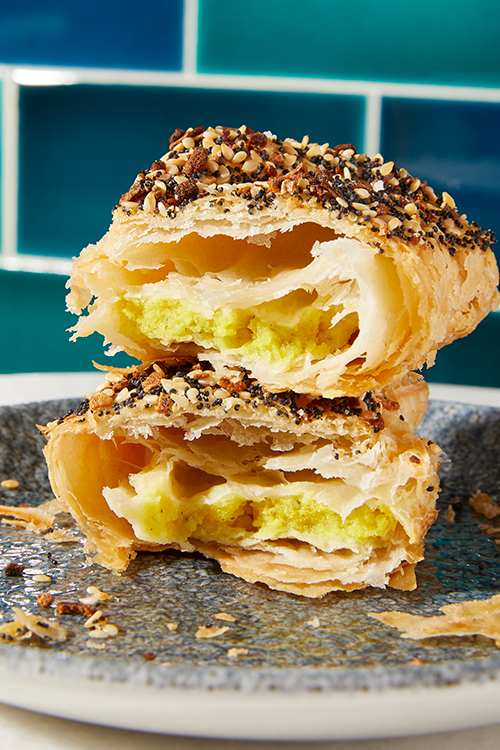 Flaky pastry torn in half to reveal gooey filling.