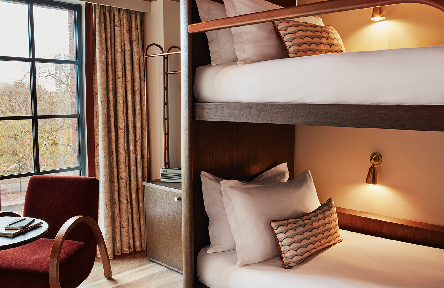Bunk beds with lighting and soft pillows plus armchair and view in a Bunk room at new hotel in Shepherd's Bush.