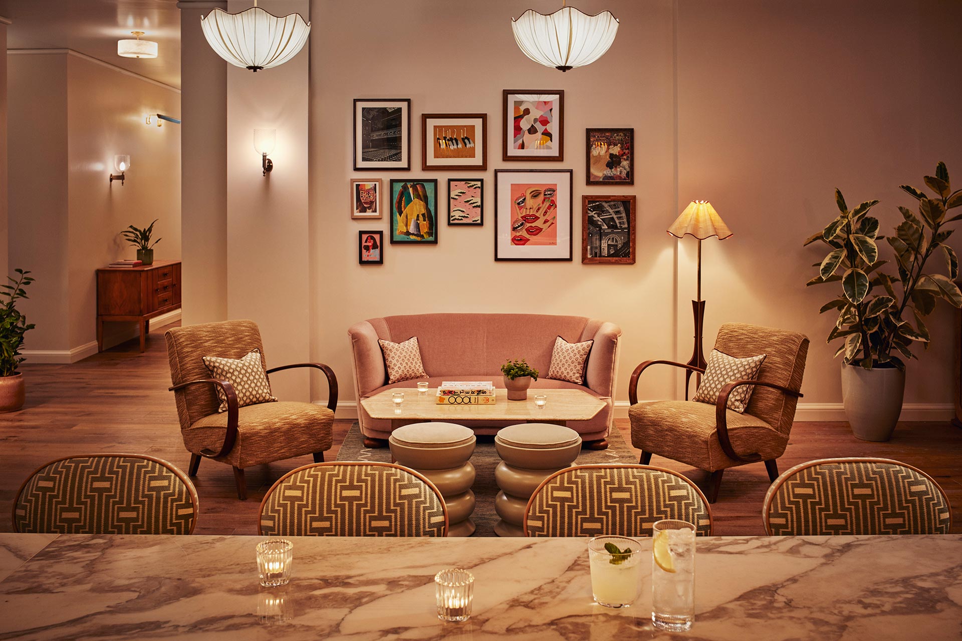 Interior view of the Pantry showing comfy chairs, marble-topped tables, paintings, green plants and a cocktail.