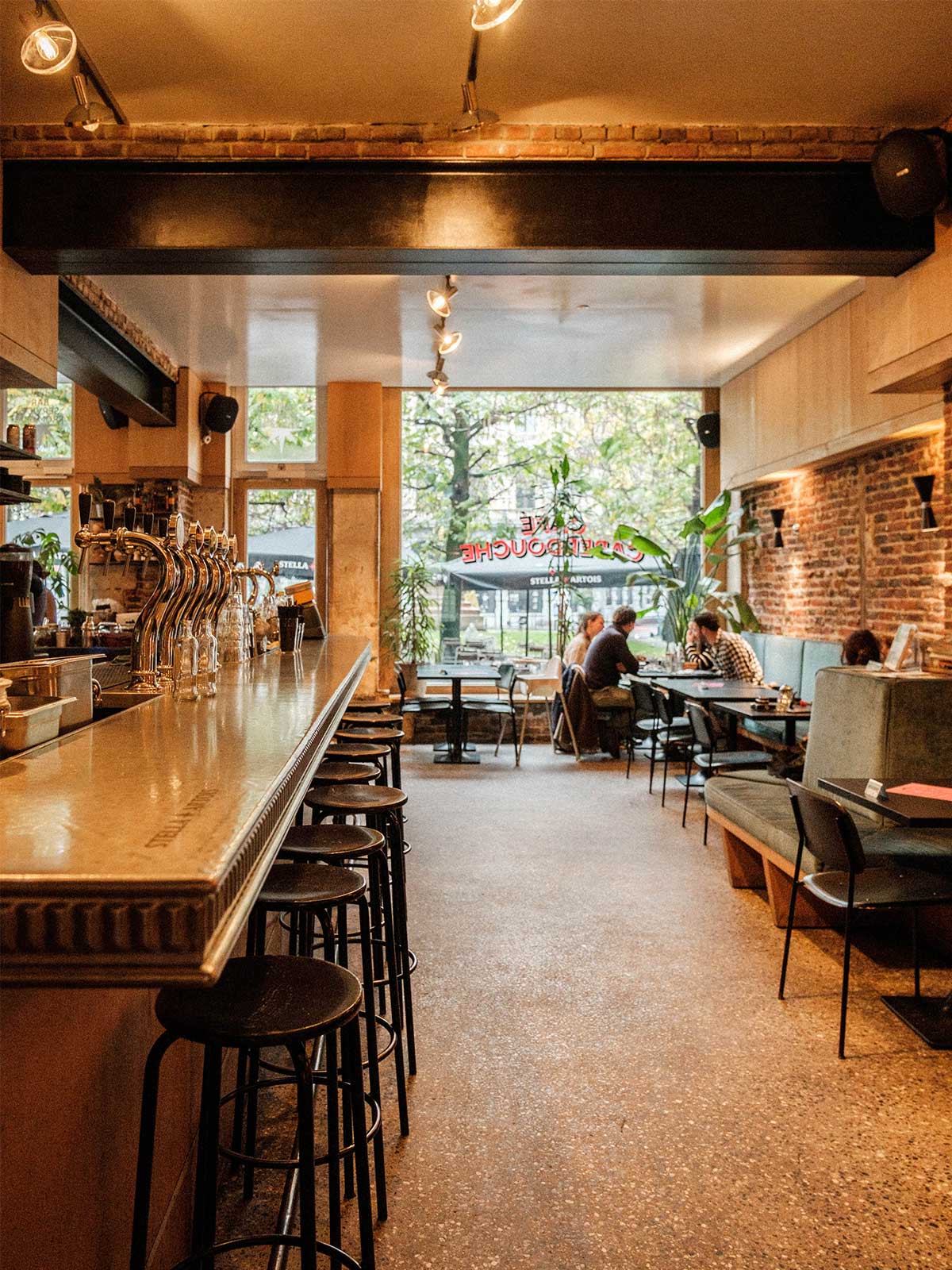 Large and friendly interior of Caberdouche showing people dining by large front windows.