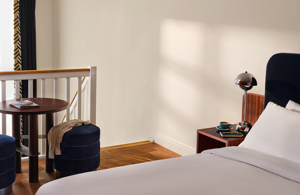 View of a double bed on a mezzanine floor with abundant natural light.