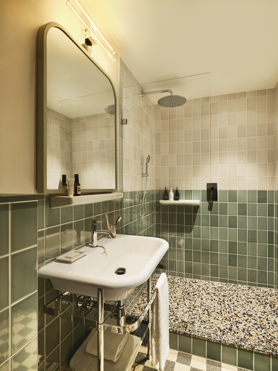 Bathroom interior with rainfall shower, sink, mirror and tiled walls