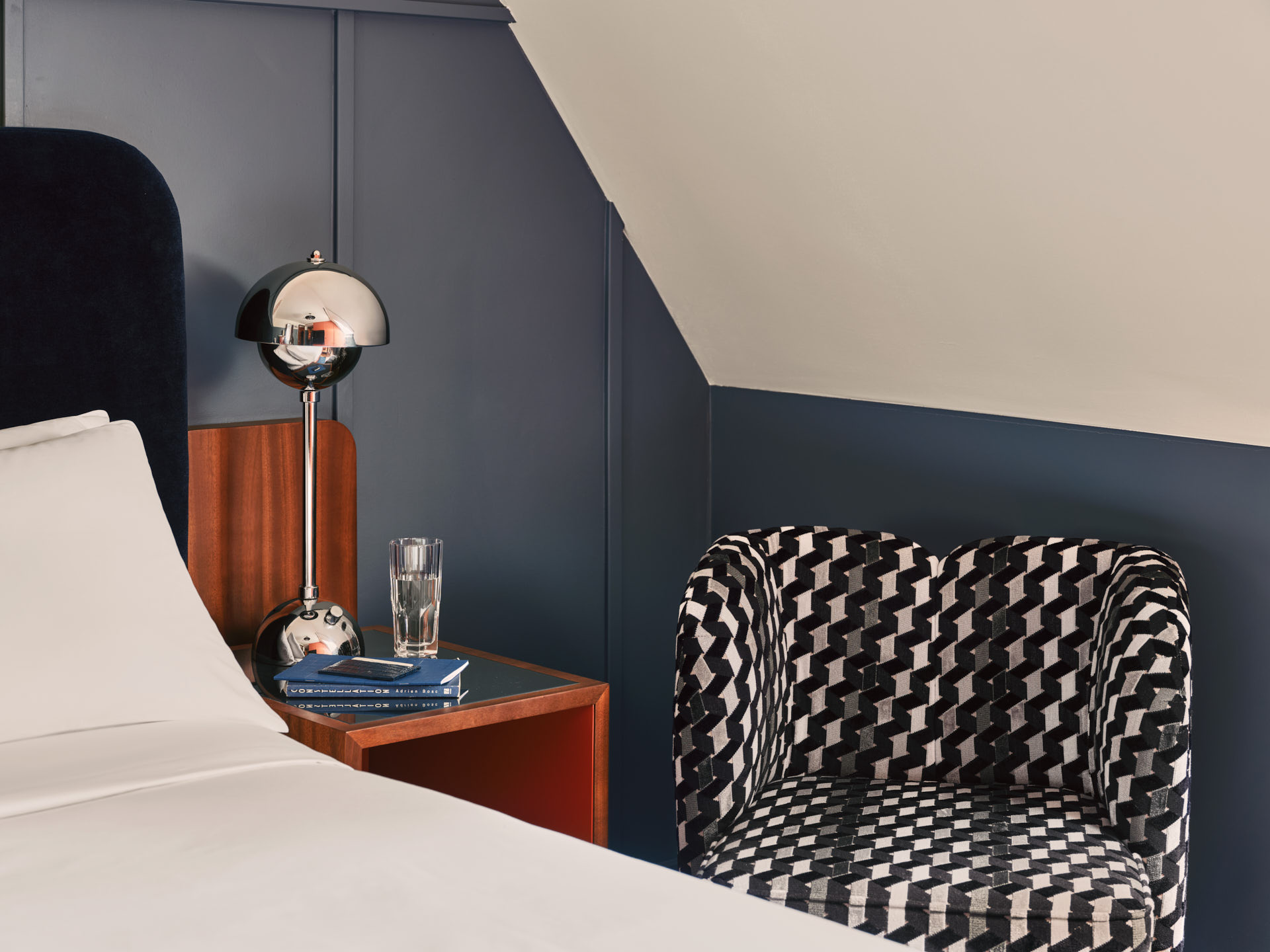 Bedside table with lamp plus cushioned armchair